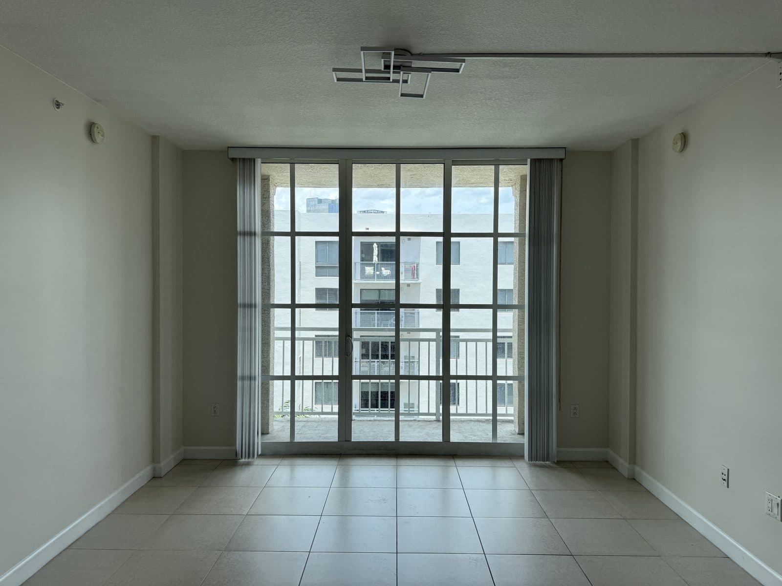 The Whitney — Residences and the Building — Residence living area — floor-to-ceiling sliders opening to the balcony
