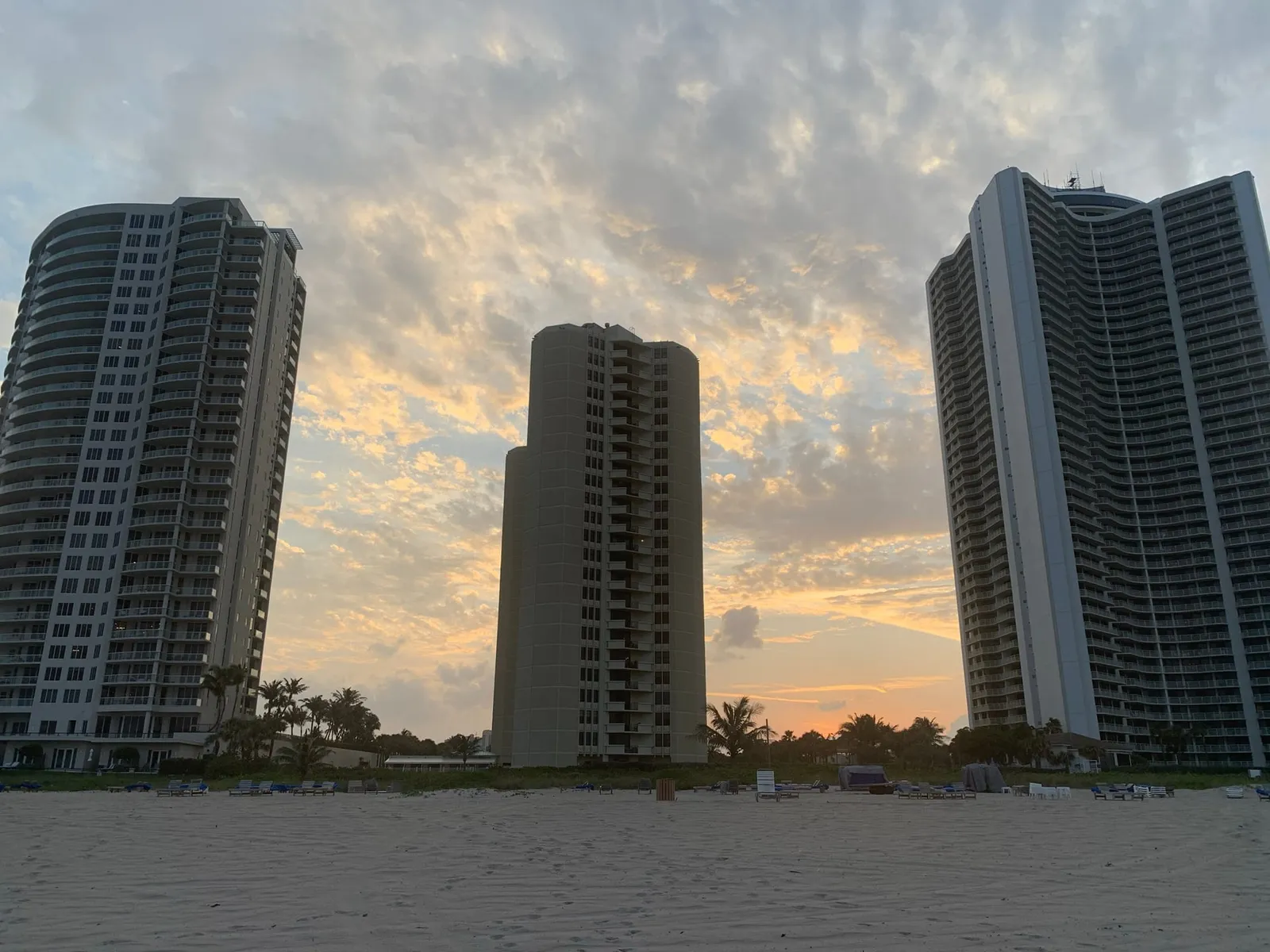 The Ritz-Carlton Singer Island at left and neighboring towers seen from the beach under a sunrise sky
