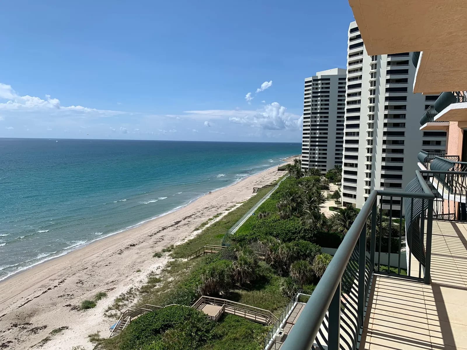 The beach and neighboring towers seen from a Via Delfino balcony, with the building's beach walkovers below